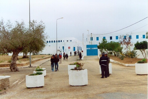 Vue d'une ruelle dans le quartier du Hara Seghira à Djerba, avec des touristes et des policiers